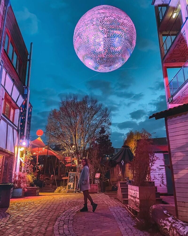 Woman standing outside under a disco ball